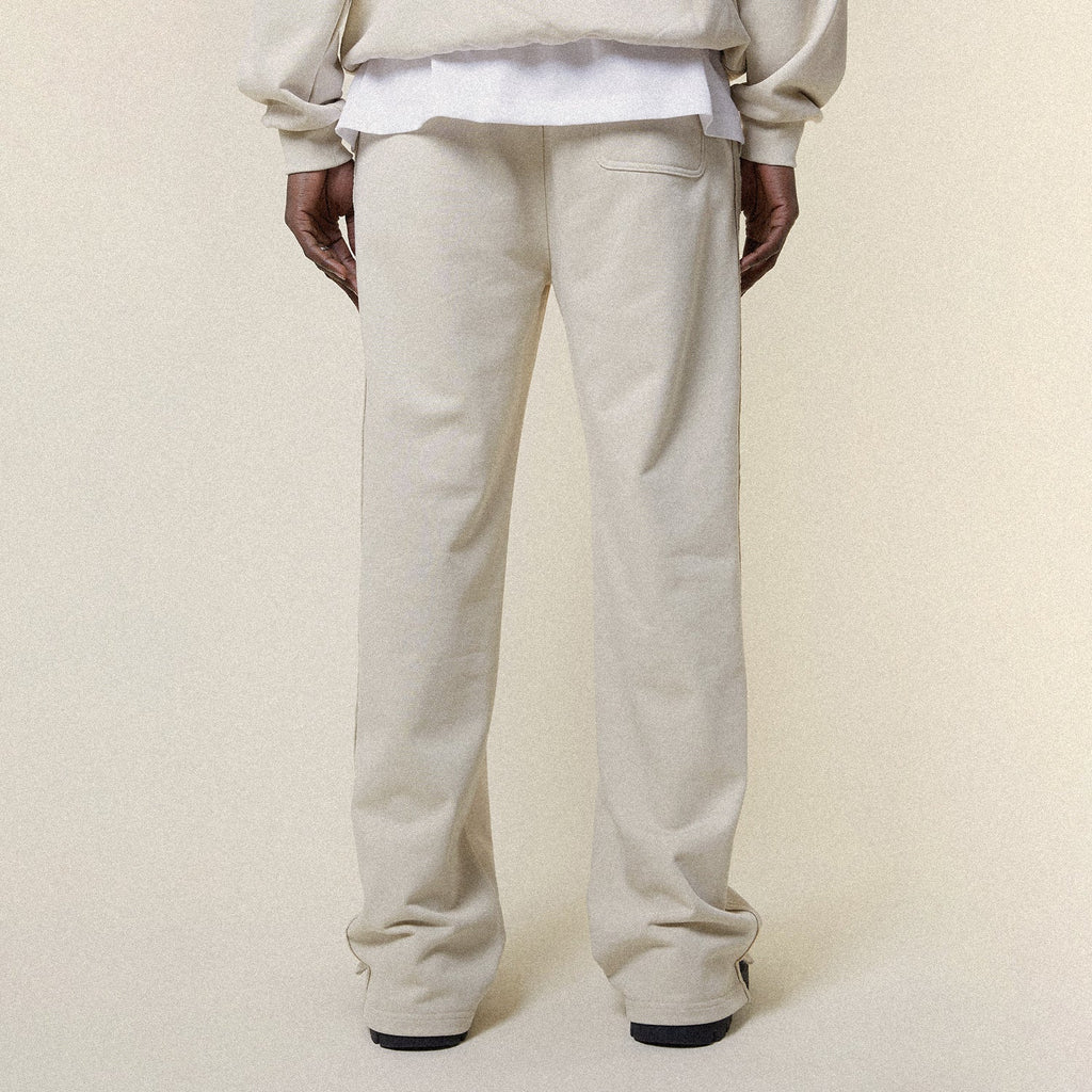 Beige pants with a BOY London logo on a white background