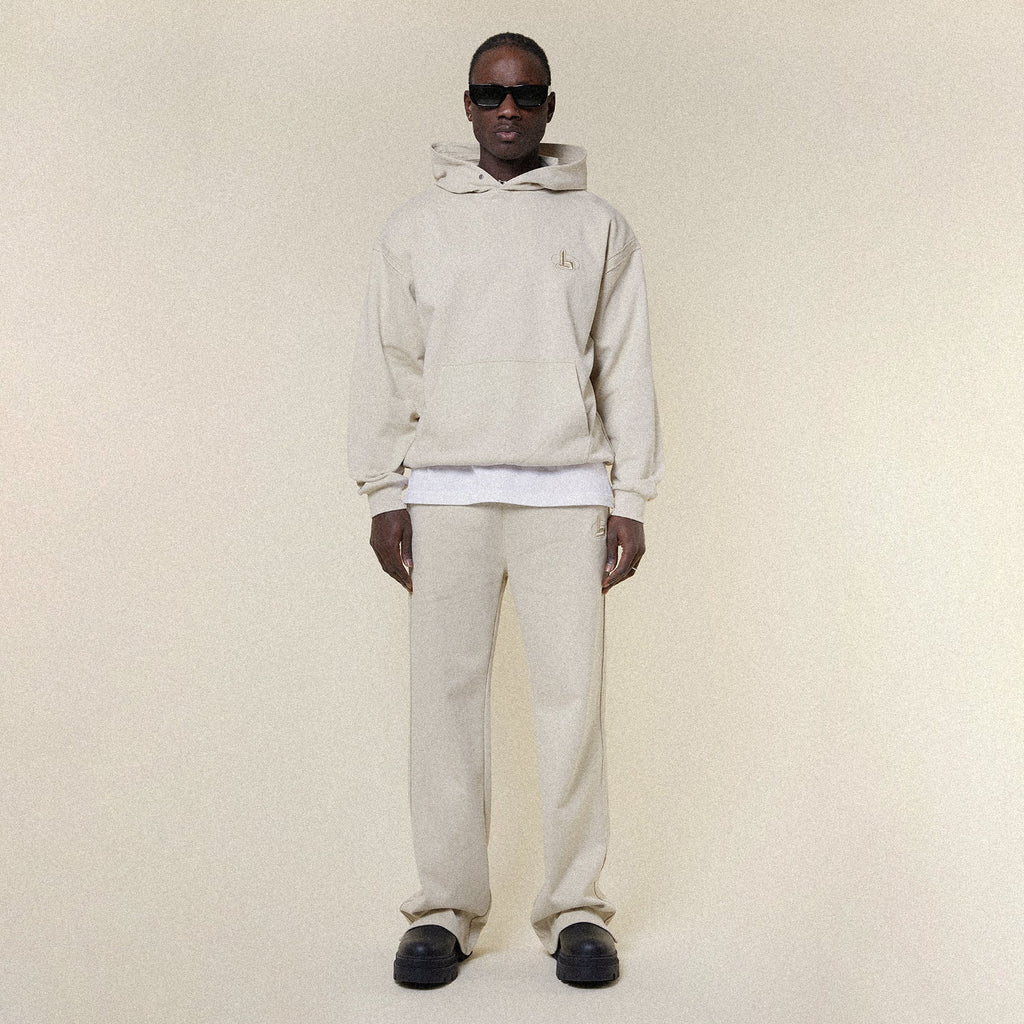 Beige pants with a BOY London logo on a white background