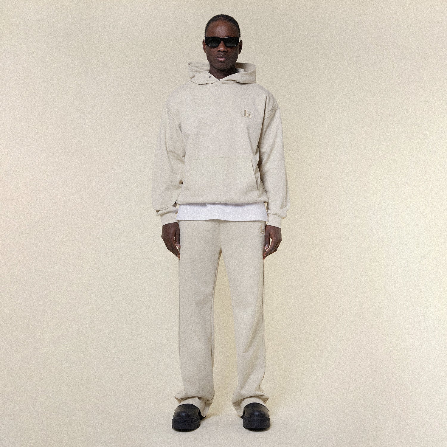 Beige pants with a BOY London logo on a white background