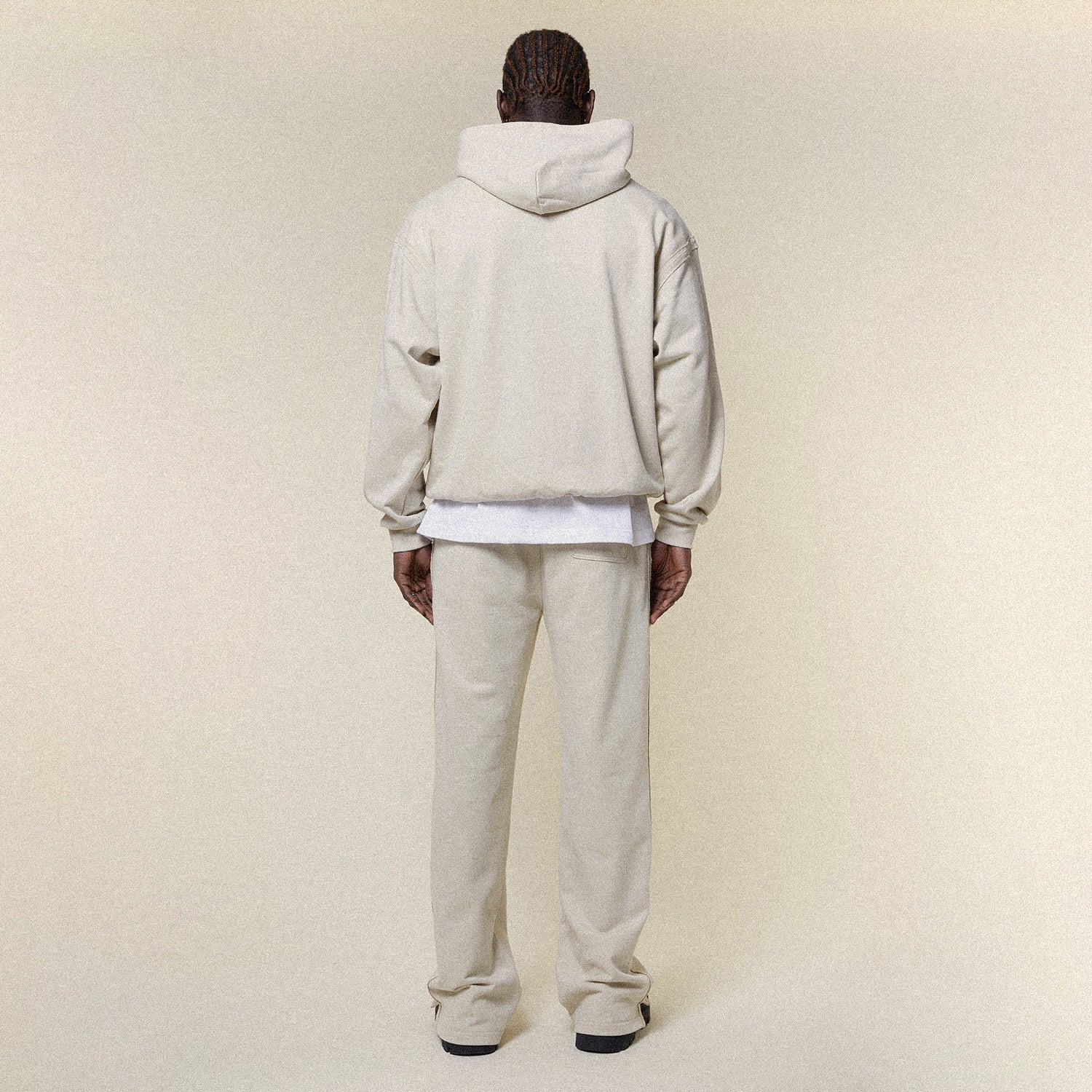 Beige pants with a BOY London logo on a white background