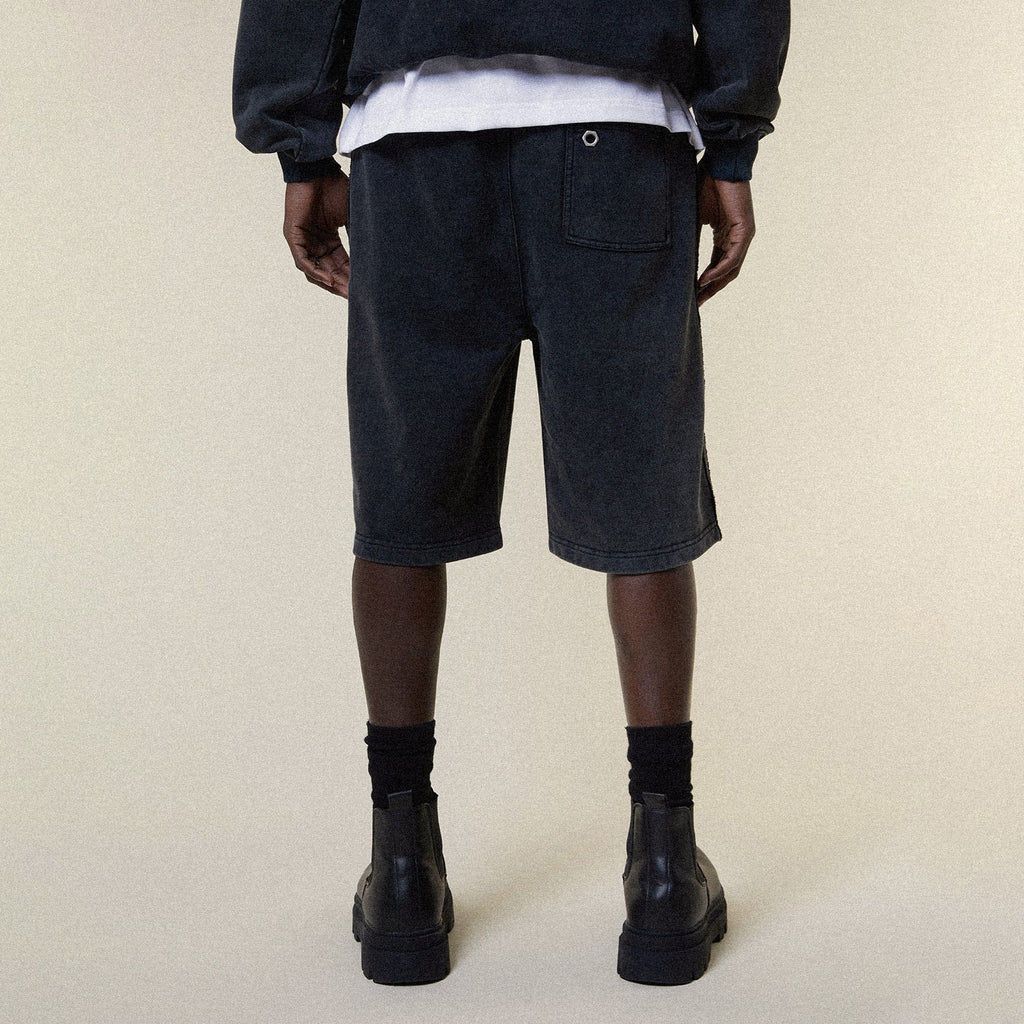 Model wearing BOY London shorts on plain background