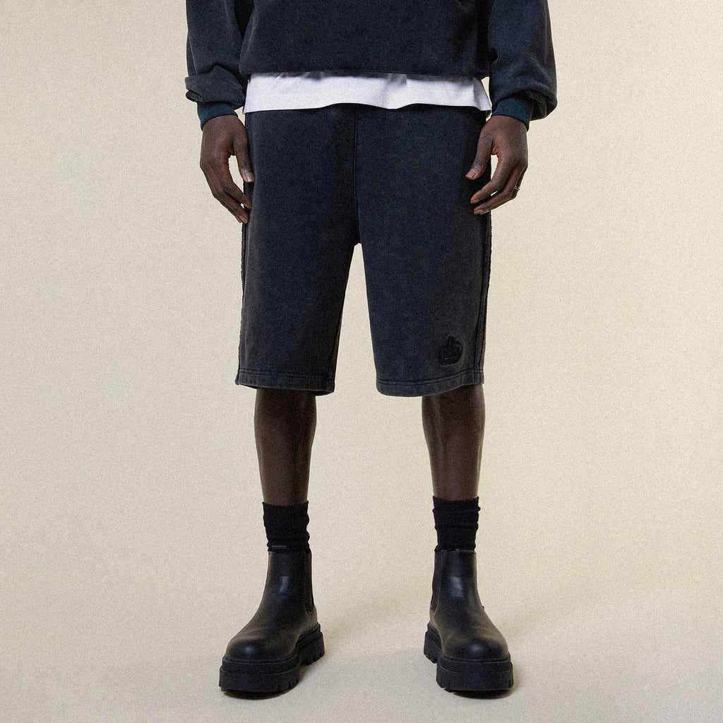 Model wearing BOY London shorts on plain background