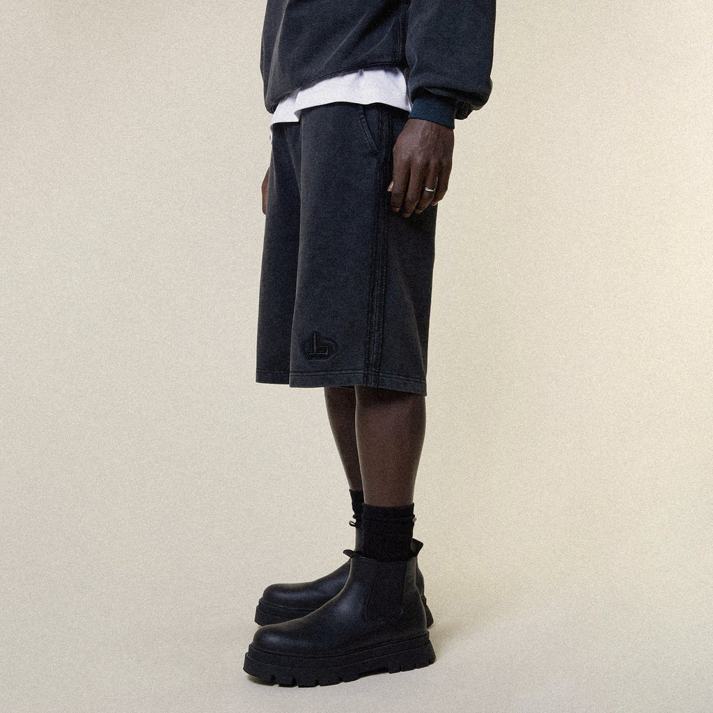 Model wearing BOY London shorts on plain background