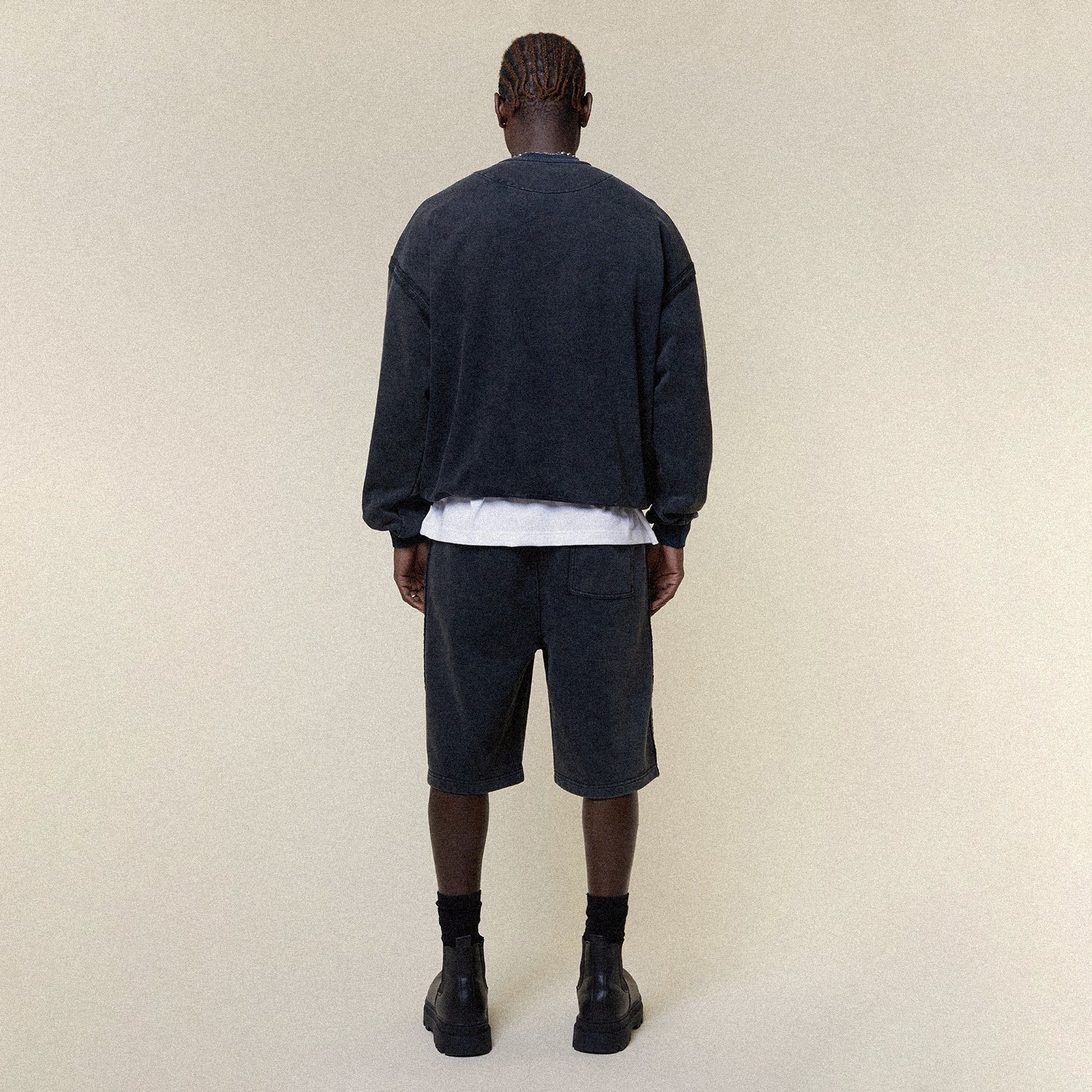 Model wearing BOY London shorts on plain background