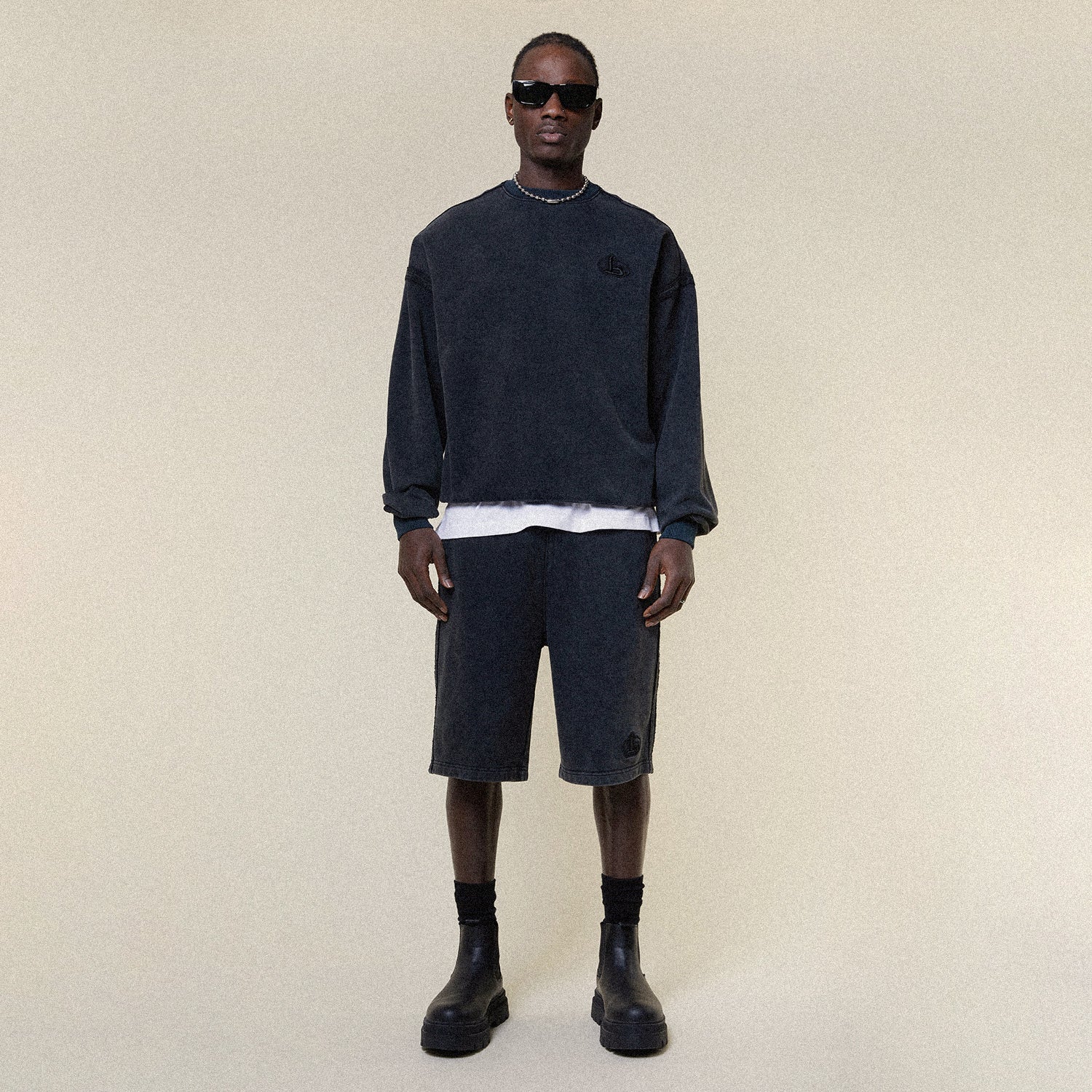 Model wearing BOY London shorts on plain background