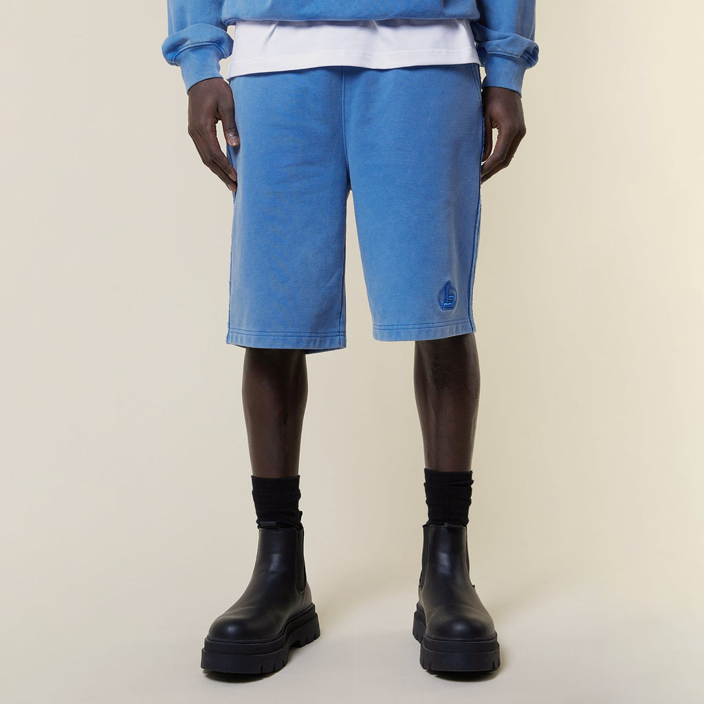 Model wearing BOY London shorts on plain background