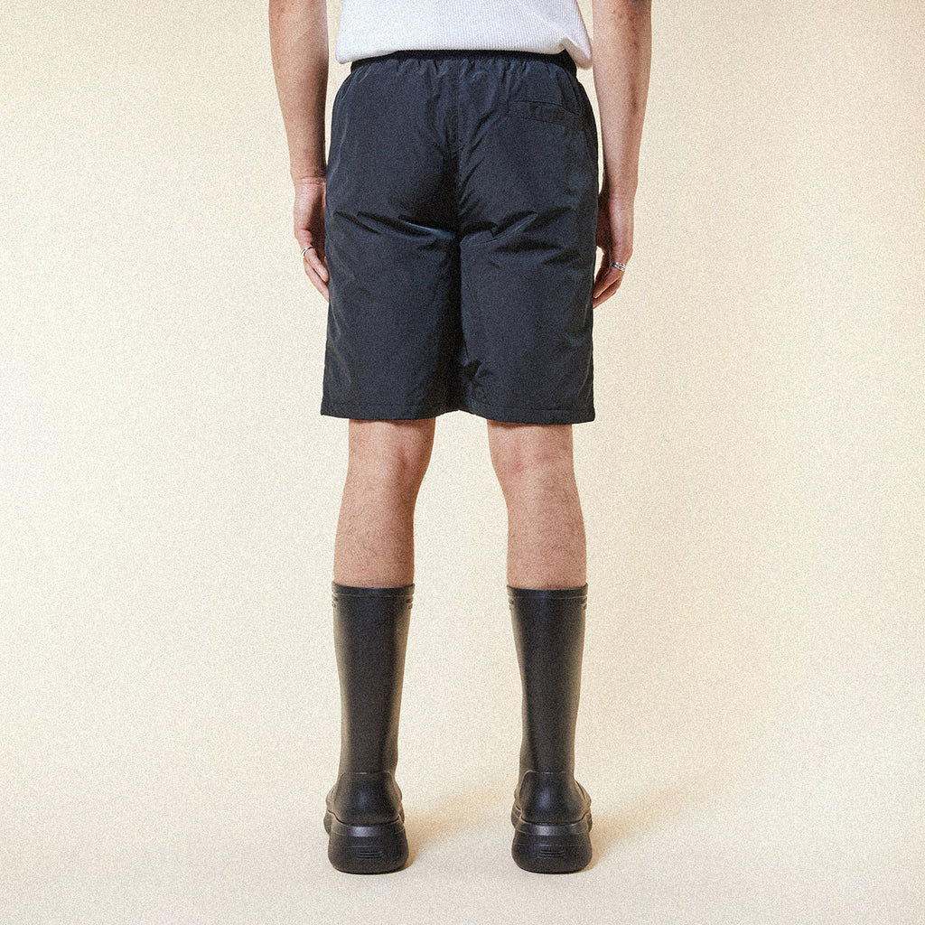 Model wearing BOY London shorts on plain background 