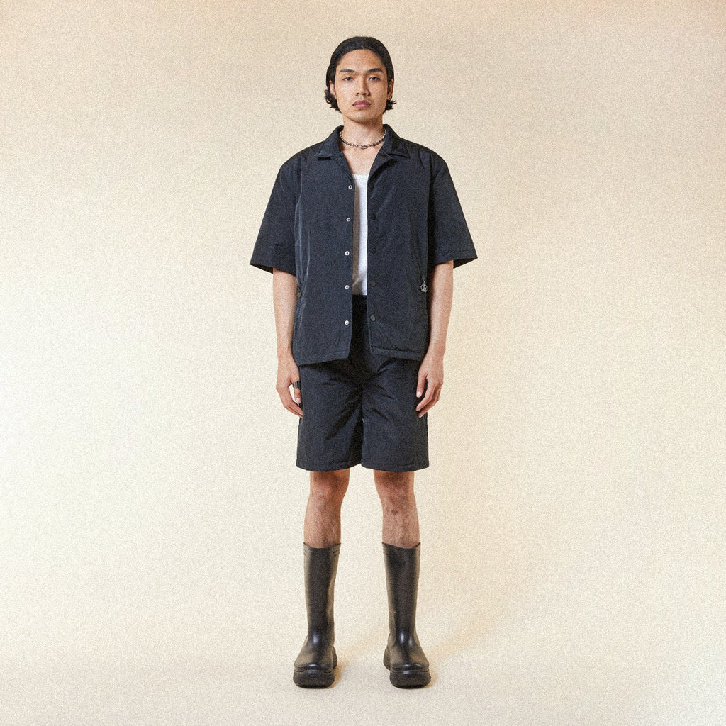 Model wearing BOY London shorts on plain background 