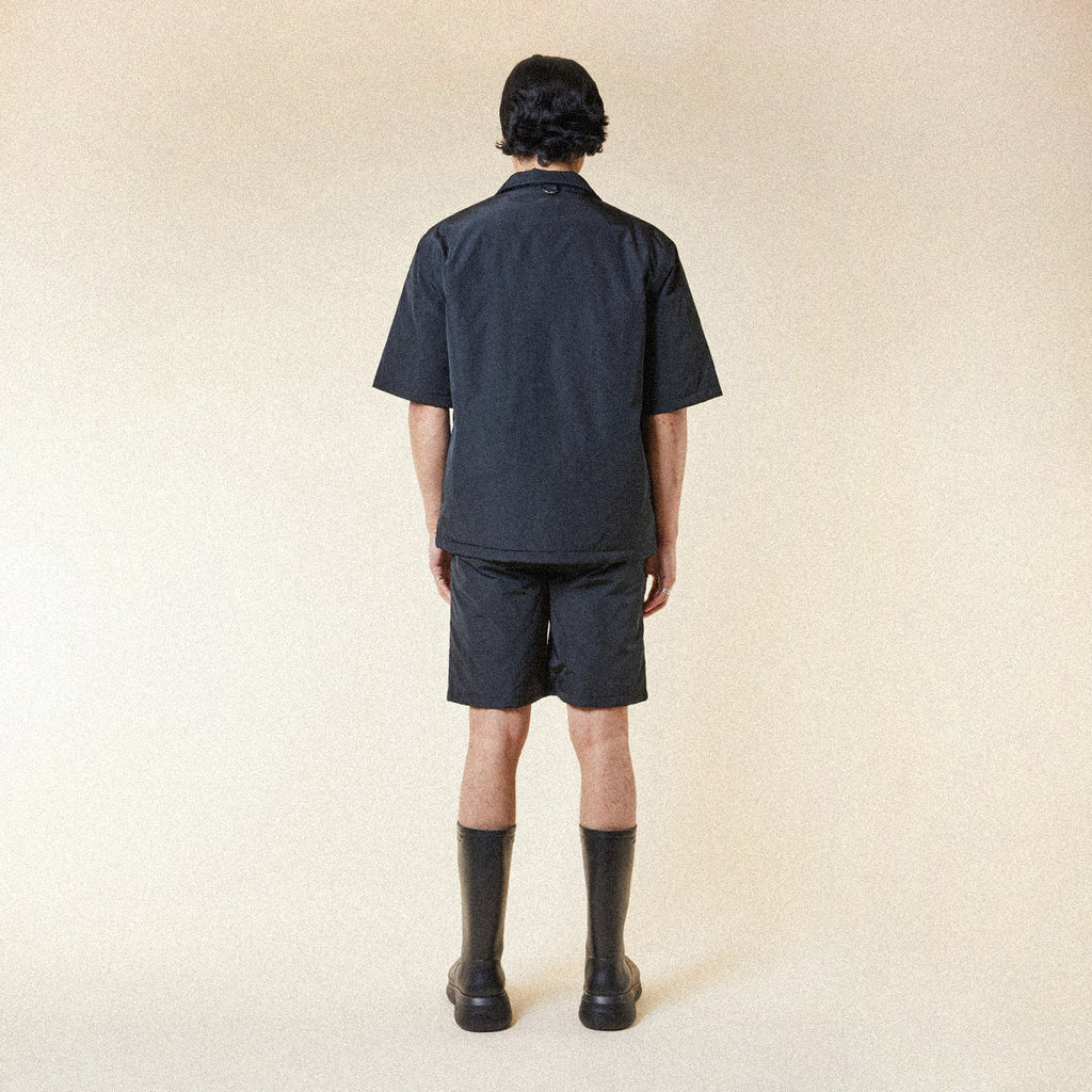 Model wearing BOY London shorts on plain background 