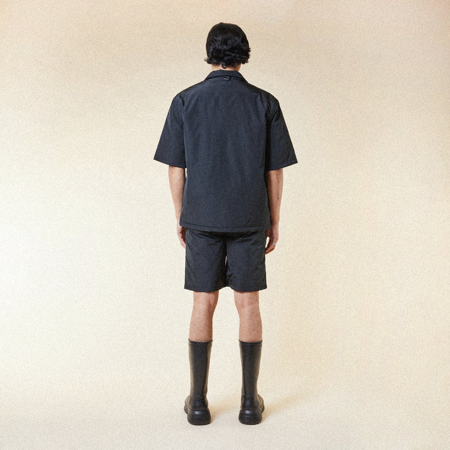 Model wearing BOY London shorts on plain background 