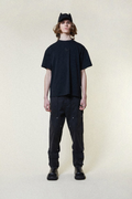 Person wearing a BOY London black t-shirt, pants, and cap on a white background