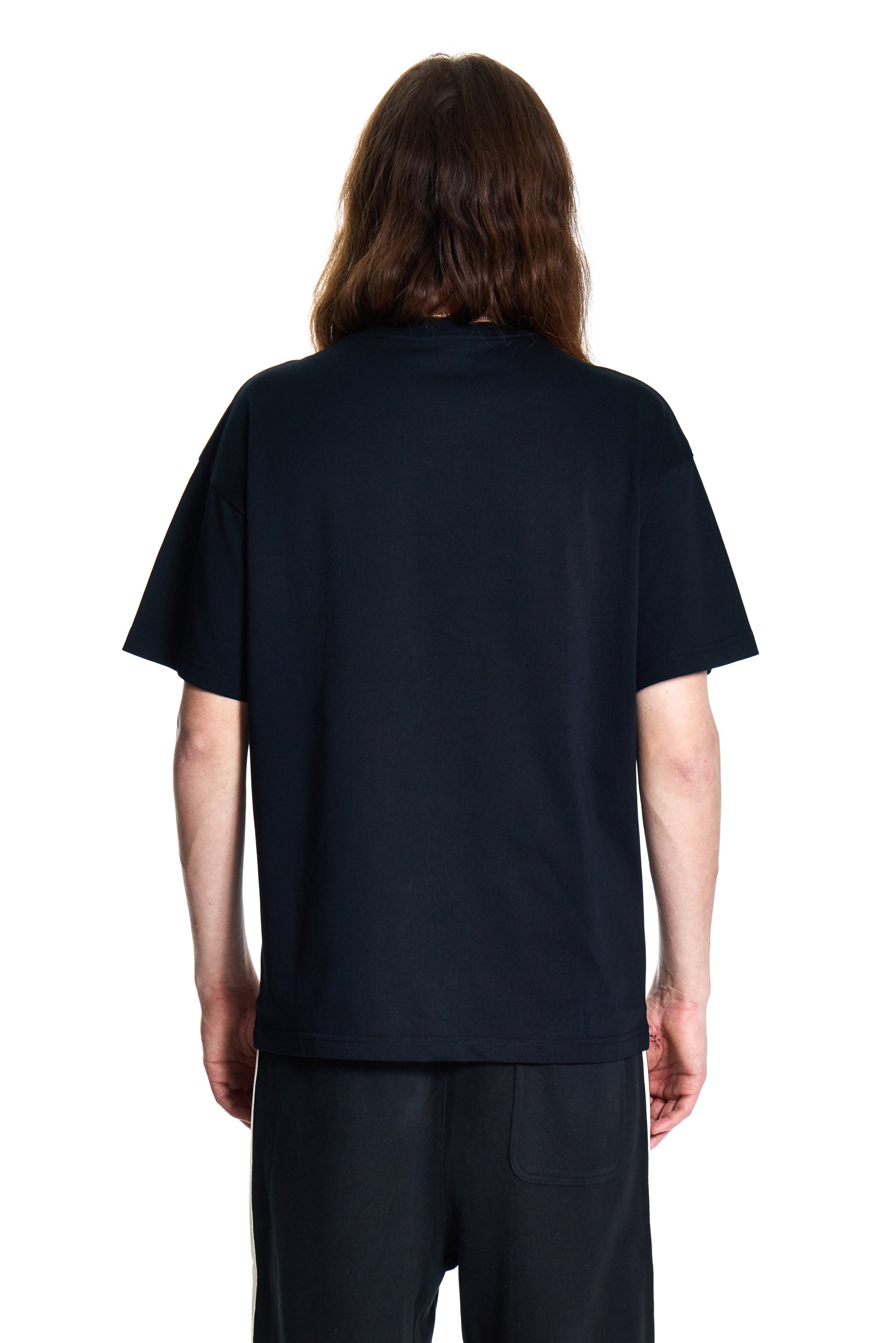 Person wearing a BOY London black t-shirt and pants on a white background