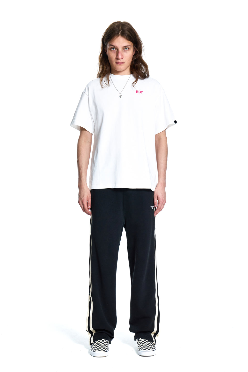 Person wearing a white t-shirt and black pants with white stripes on a white background