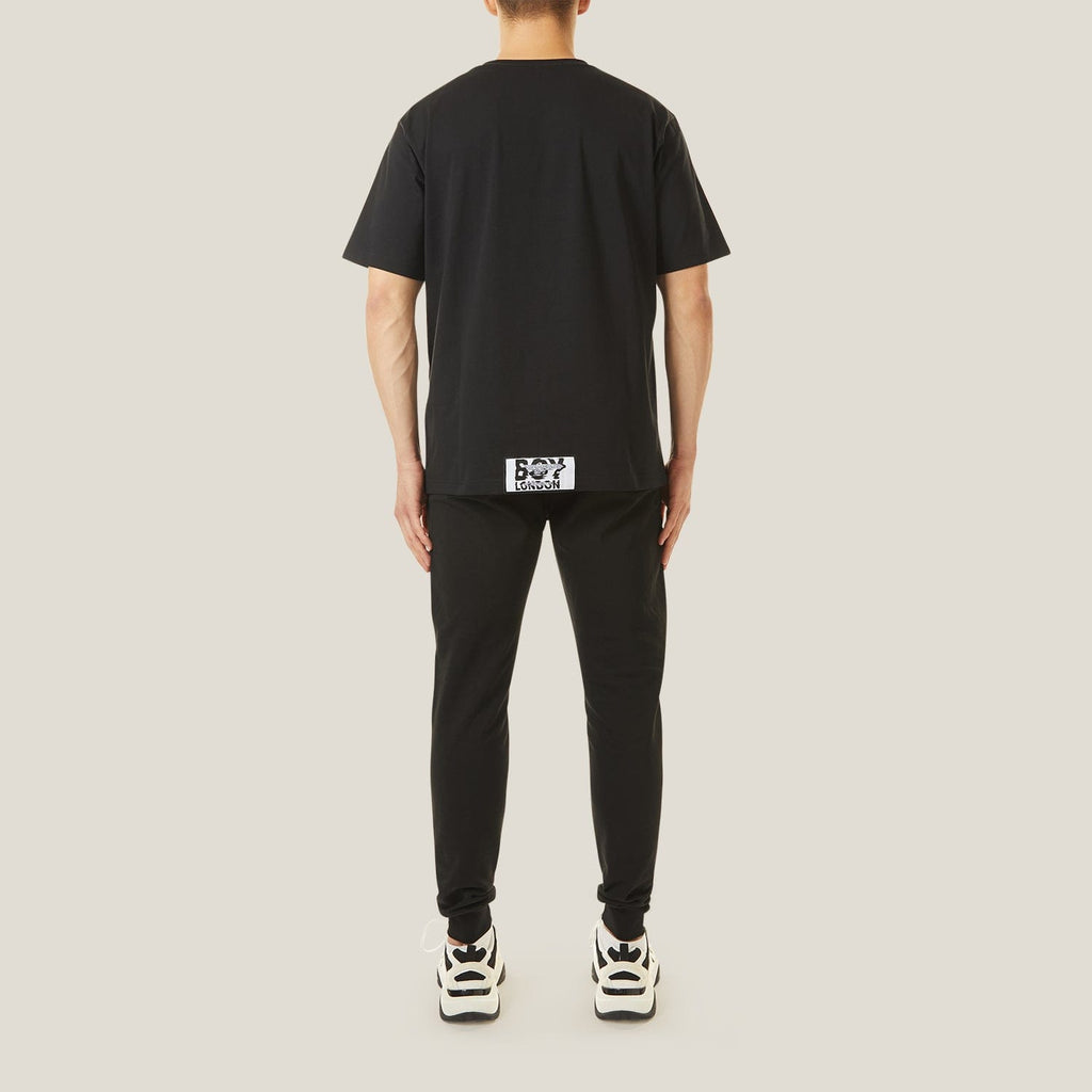 Model wearing boy london joggers on plain background