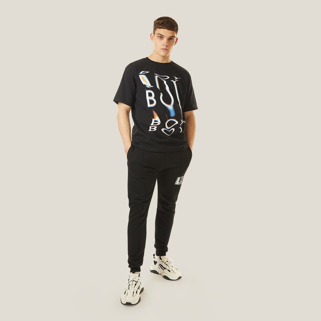 Model wearing boy london joggers on plain background