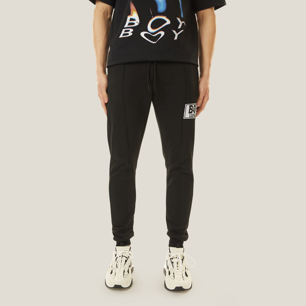 Model wearing boy london joggers on plain background