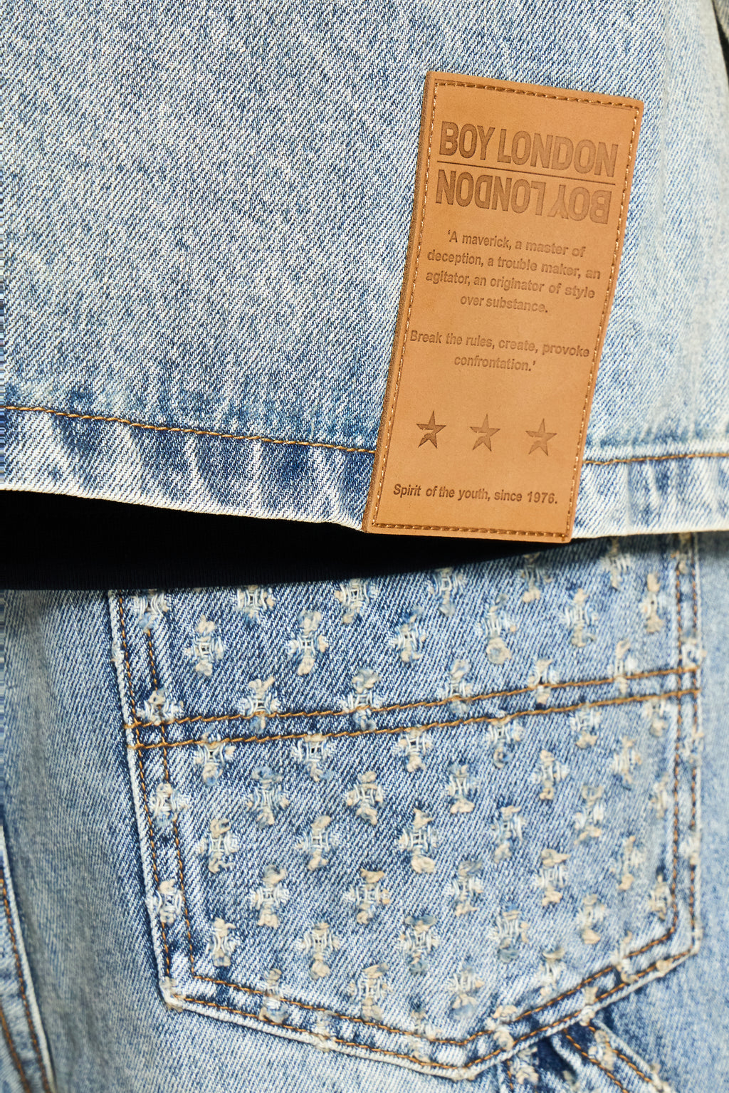 Close-up of a denim pocket with a brand label on a light blue denim fabric.