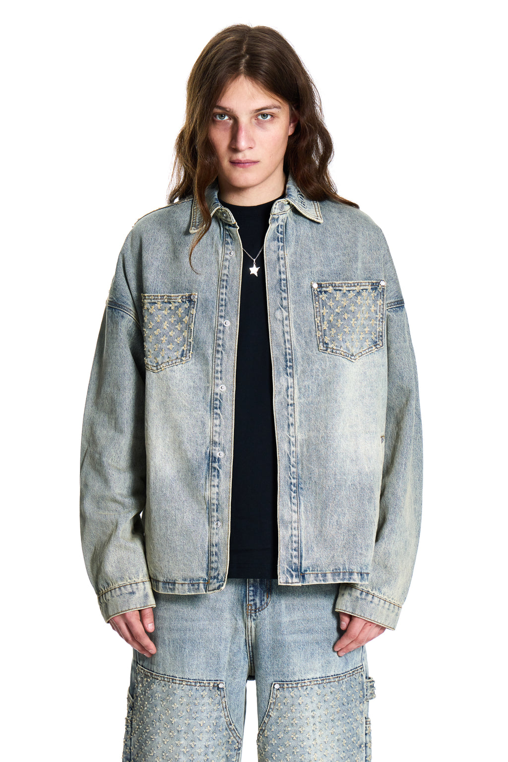 Person wearing a light blue denim jacket on a white background