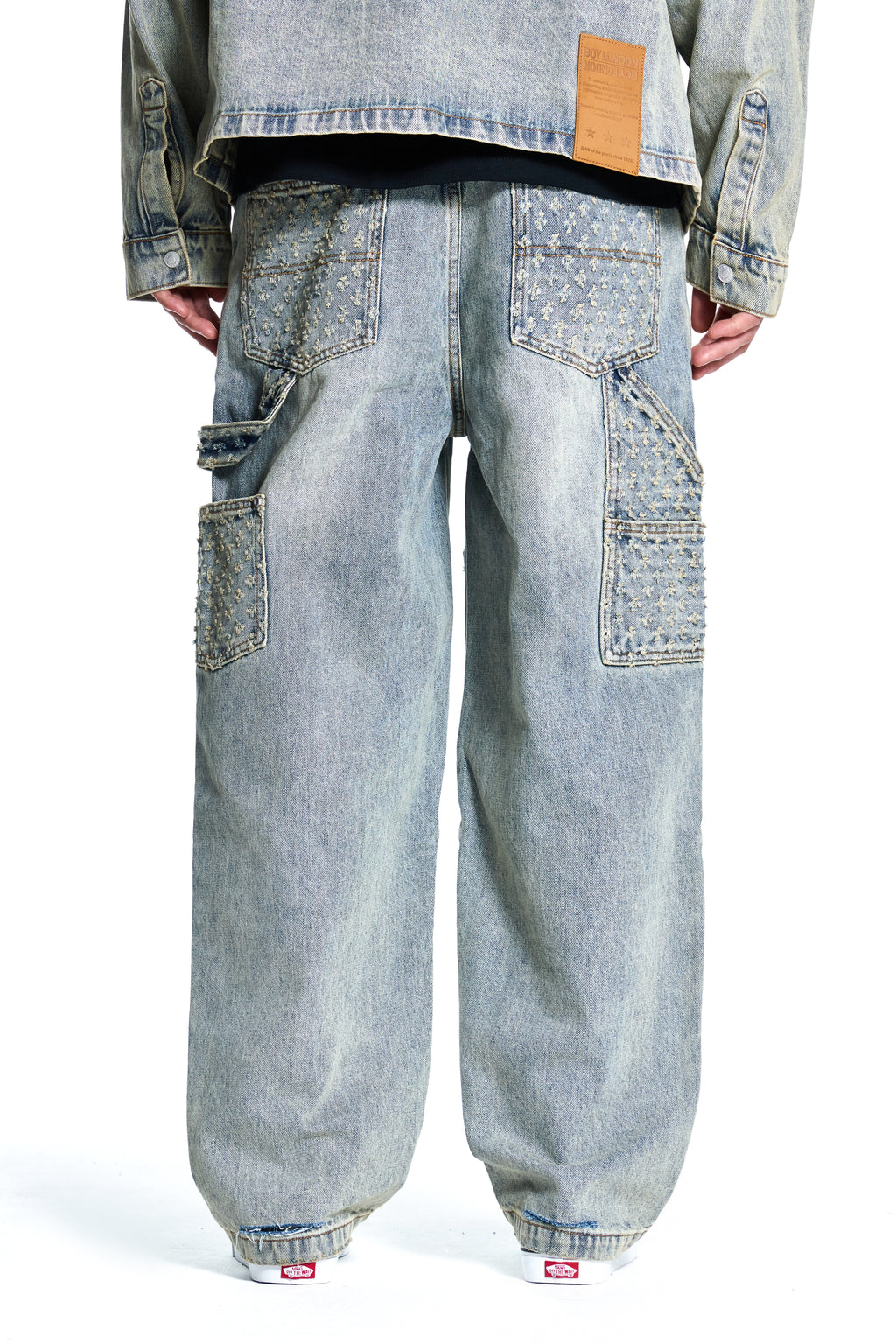 Light blue BOY London jeans worn by a person on a white background