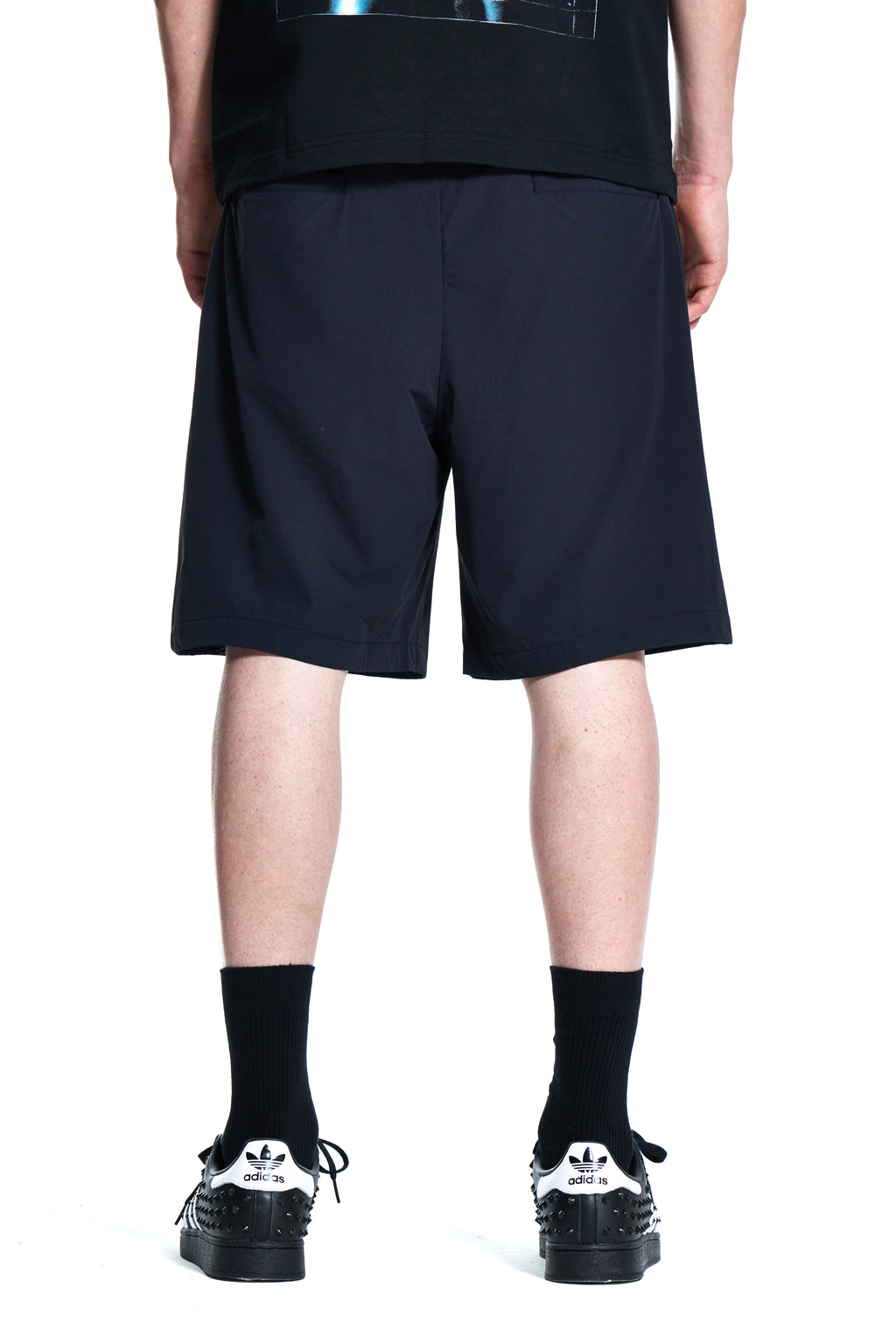 Person wearing Boy London black nylon shorts with a graphic design and black shorts on a white background