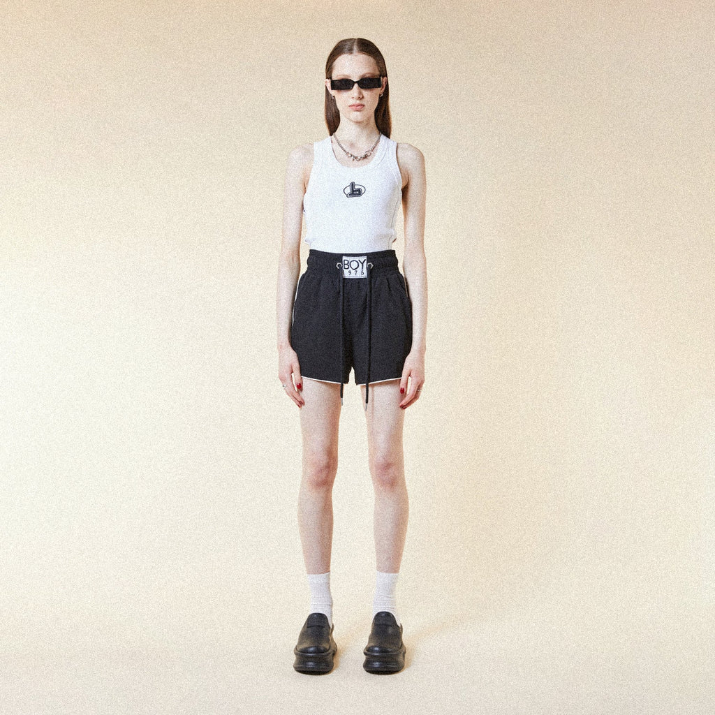 Model wearing BOY London shorts on plain background