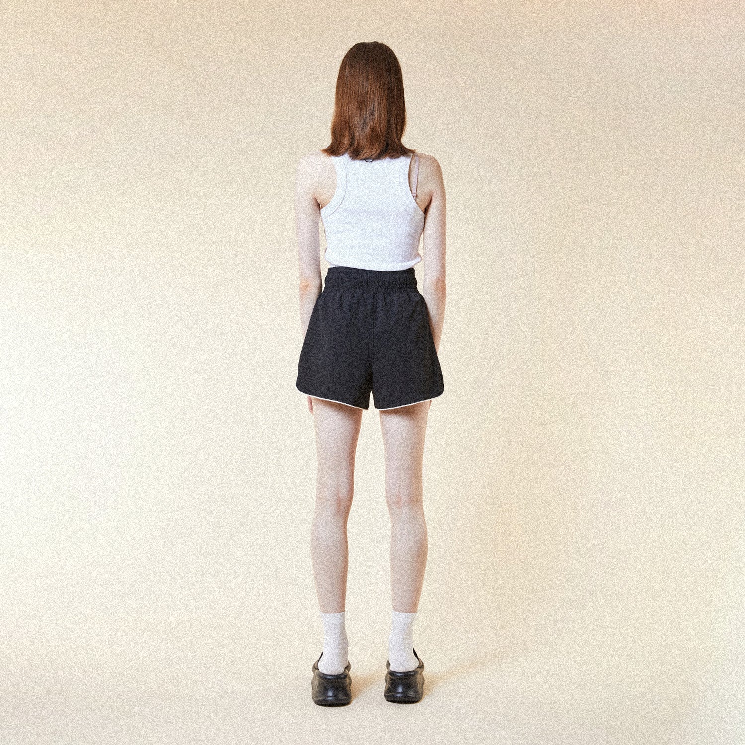 Model wearing BOY London shorts on plain background