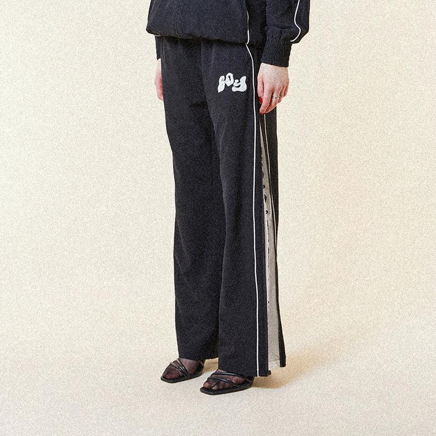 Black BOY London pants with white text on a white background