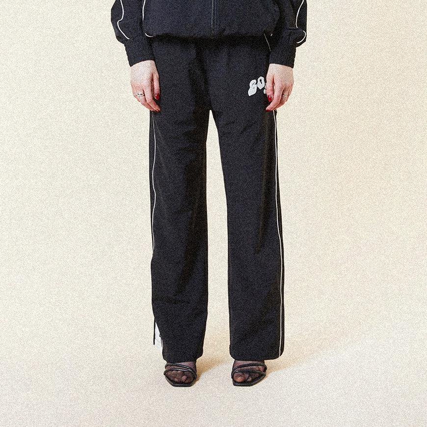 Black BOY London pants with white text on a white background