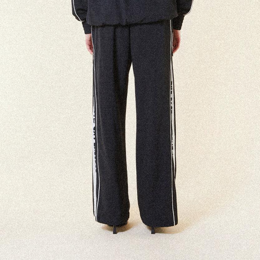 Black BOY London pants with white text on a white background