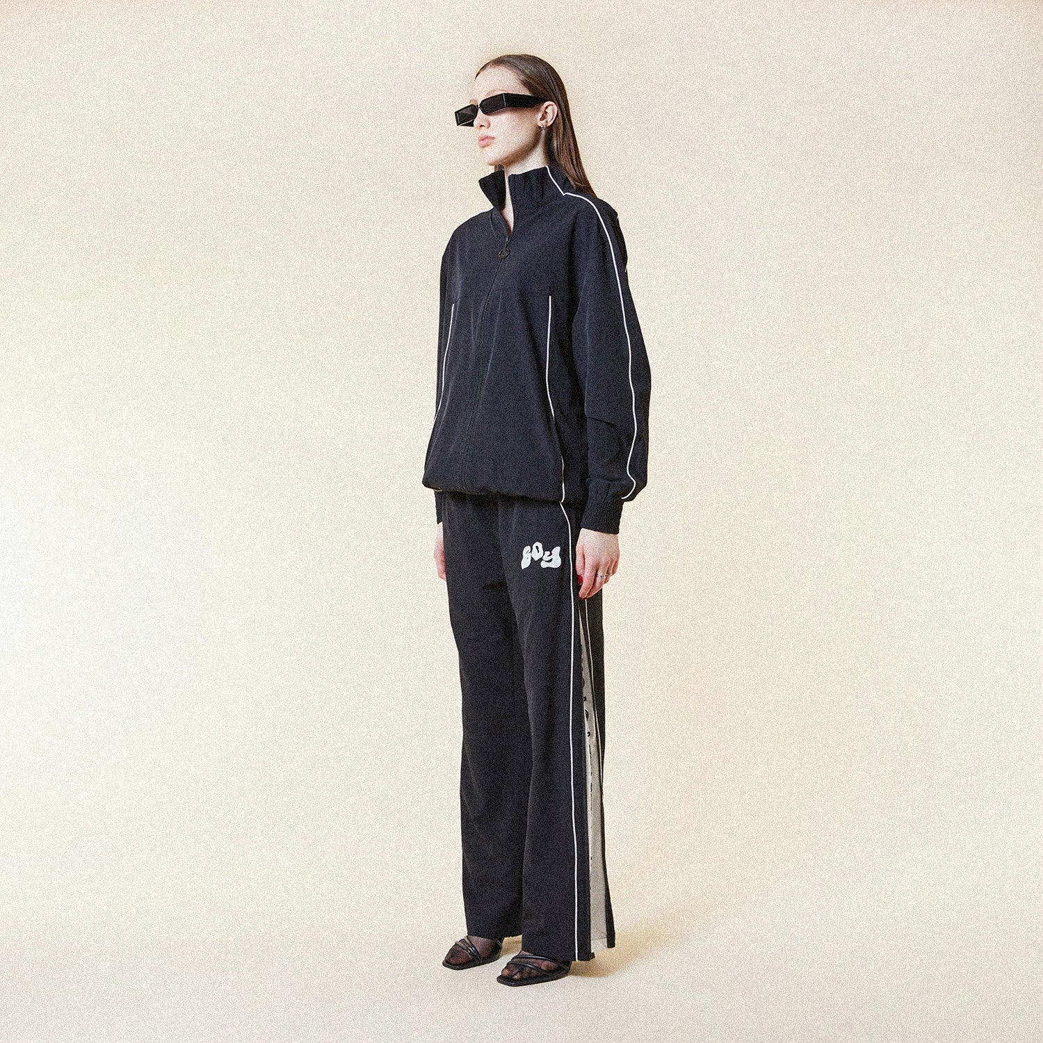 Black BOY London pants with white text on a white background