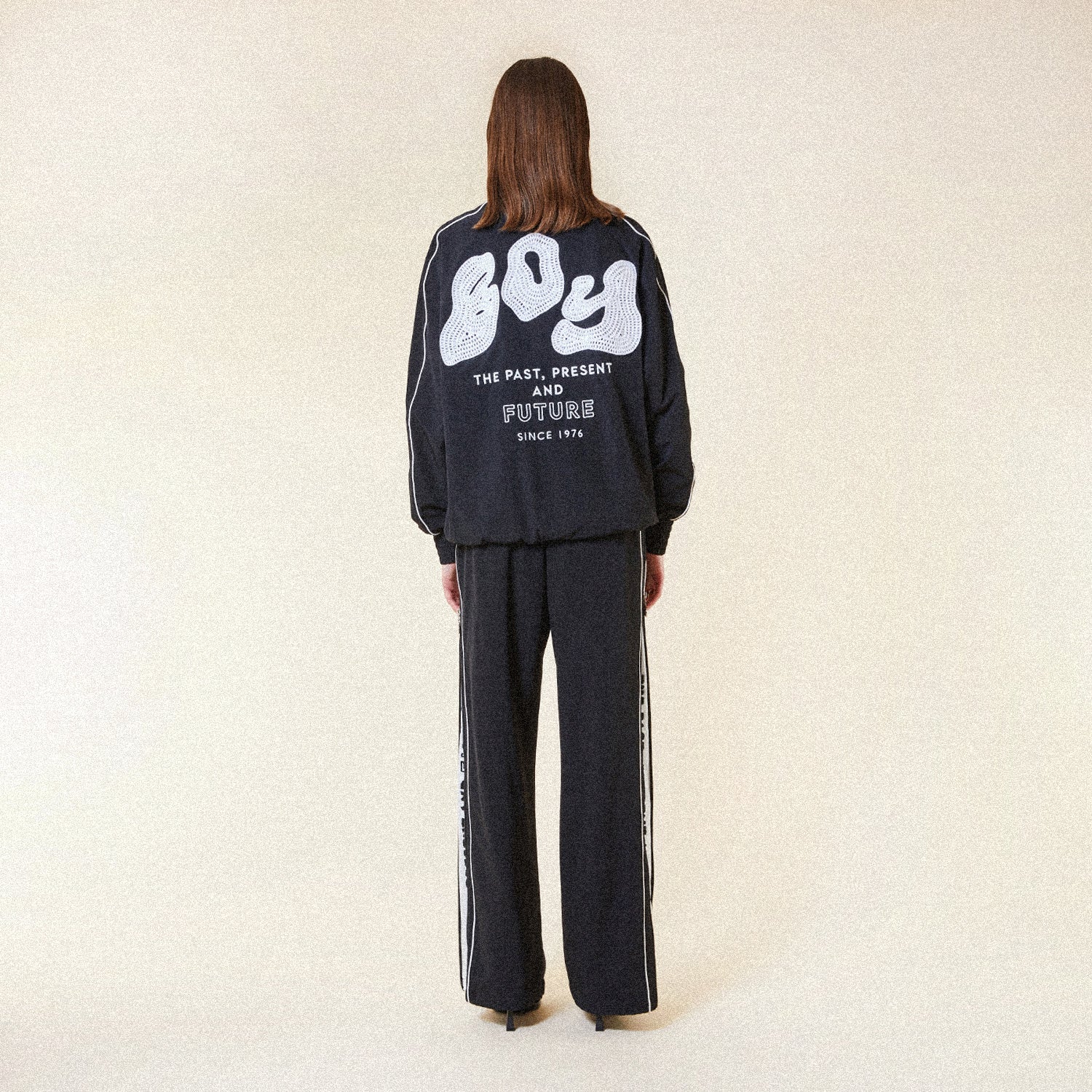 Black BOY London pants with white text on a white background