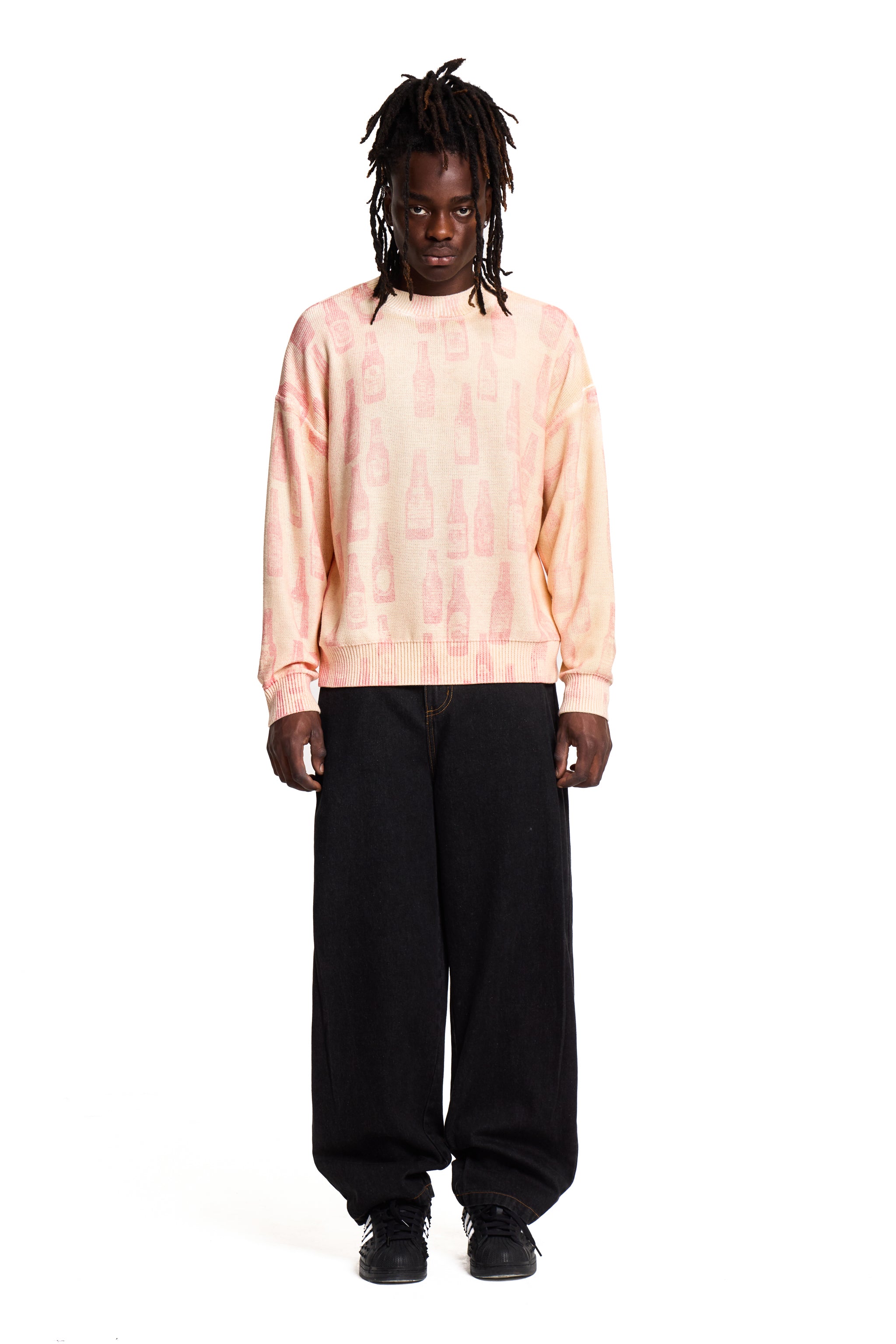 Person wearing a light Boy London pink tie-dye sweatshirt and black pants on a white background