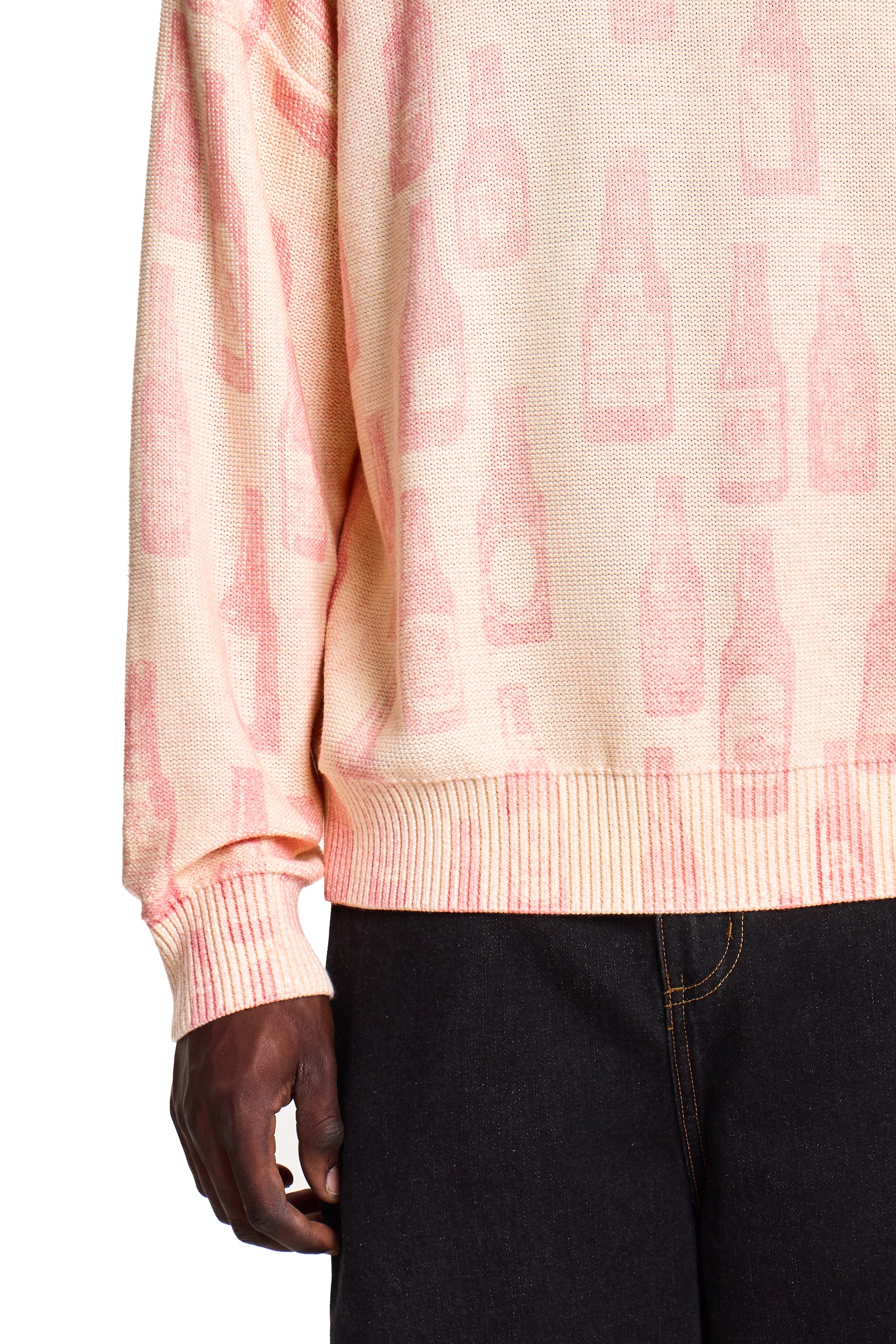 Person wearing a pink Boy London sweater with a subtle pattern on a white background