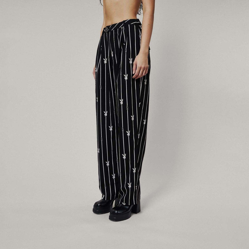 Model wears BOY London trousers on white background