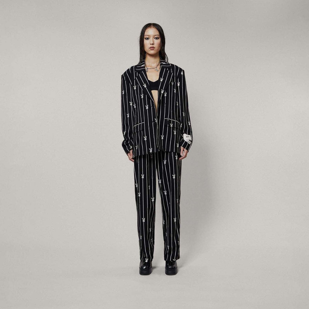 Model wears BOY London trousers on white background