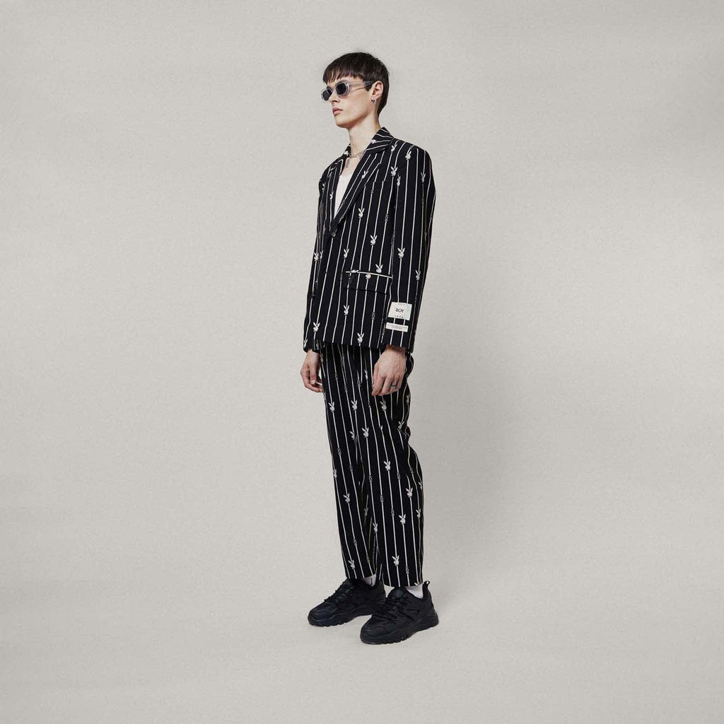 Model wears BOY London trousers on white background