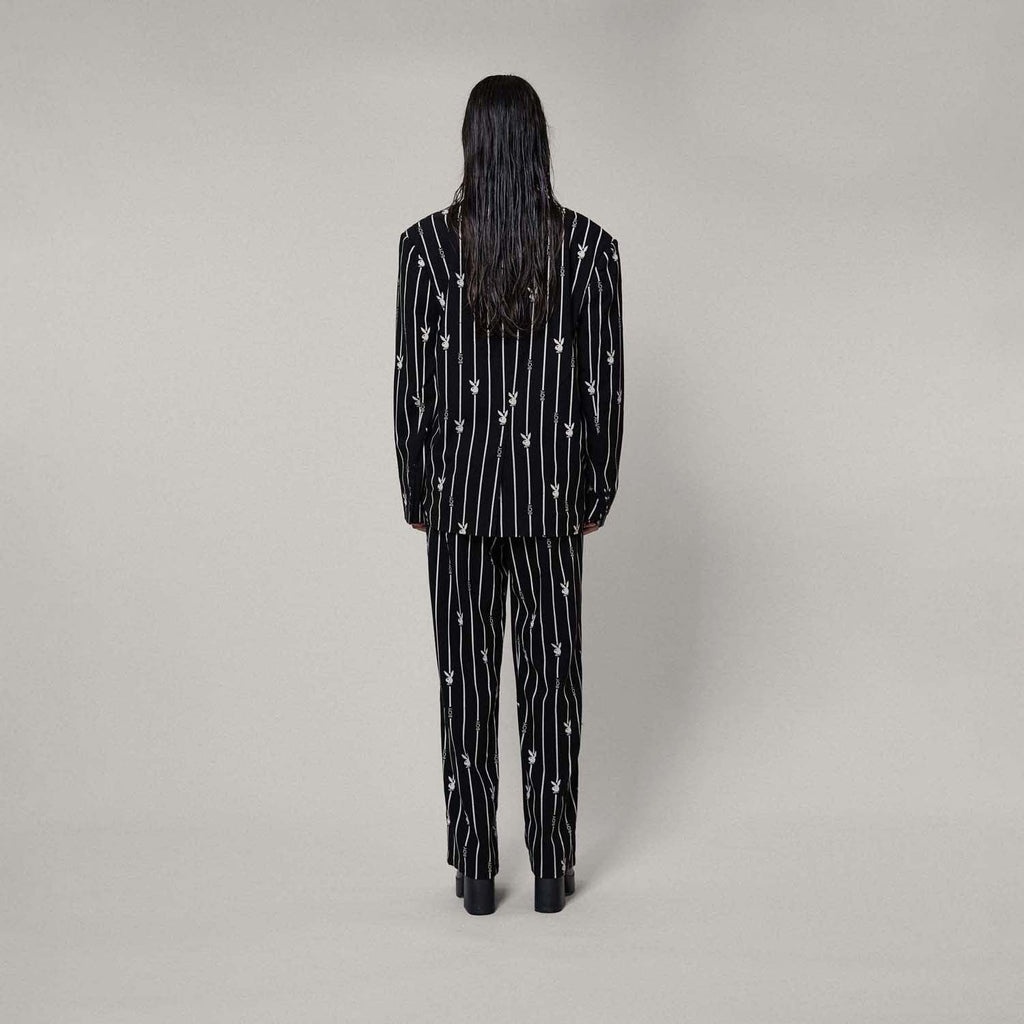 Model wears BOY London trousers on white background