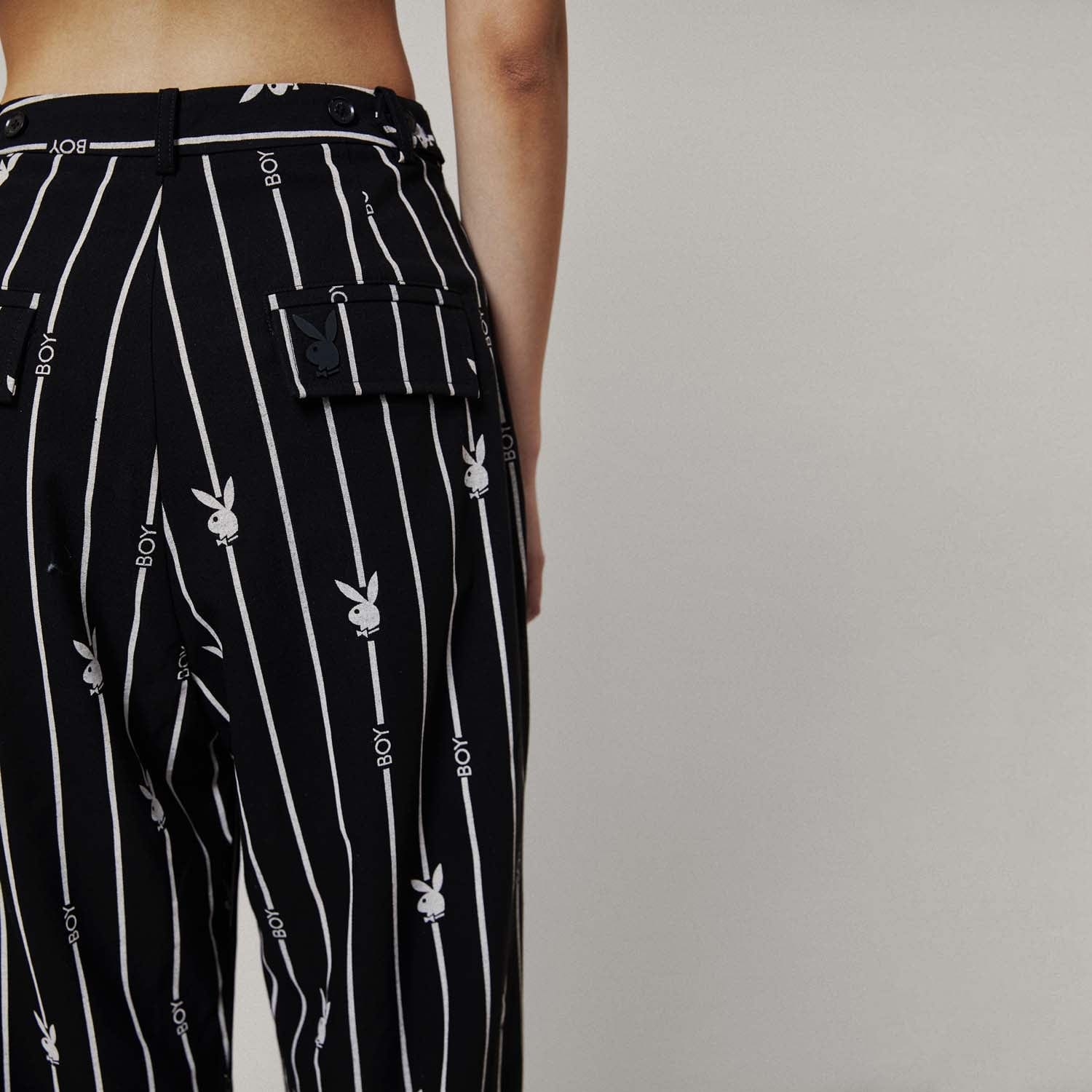 Model wears BOY London trousers on white background