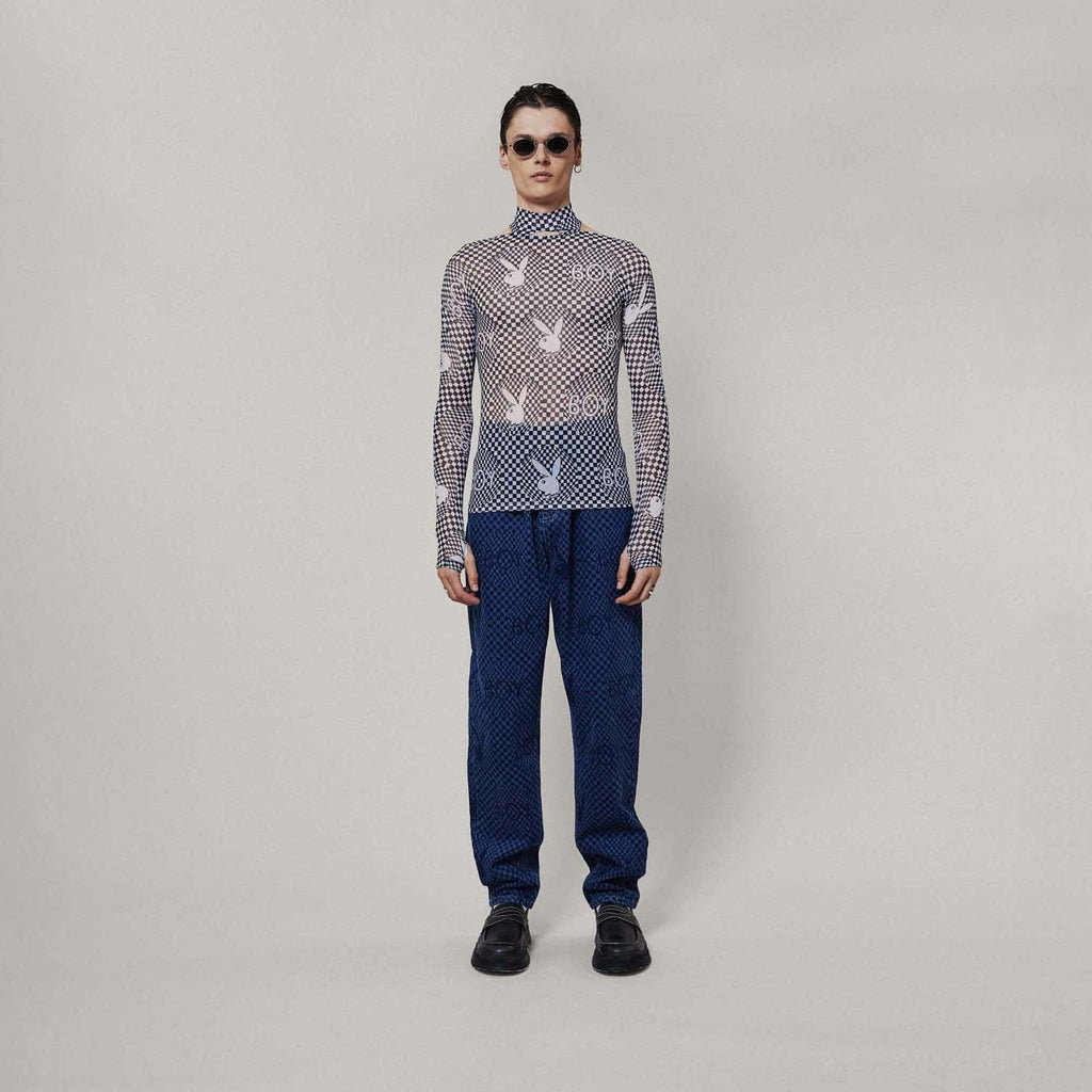 Model wearing Black and white checkered BOY London top with graphic design on a white background
