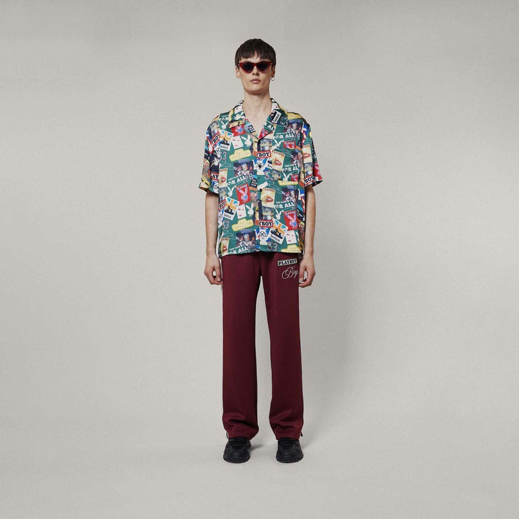 Model wearing Colourful BOY London patterned shirt with brand logos on a white background