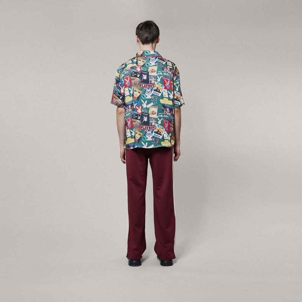 Model wearing Colourful BOY London patterned shirt with brand logos on a white background