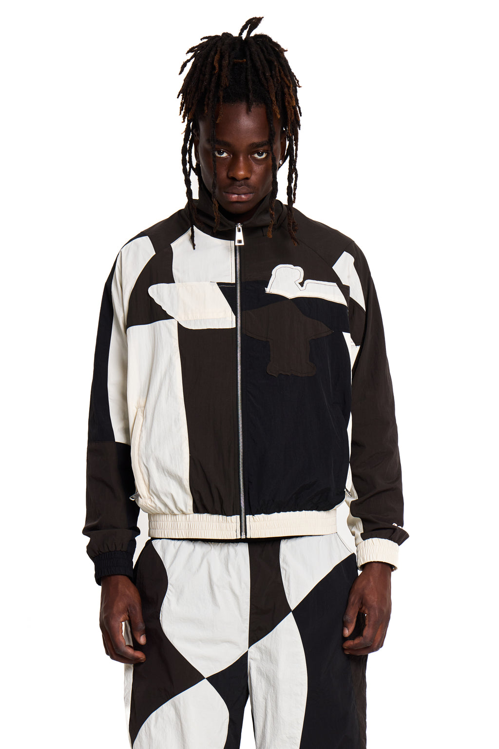 Person wearing a black and white Boy London checkered outfit with a prominent logo on a white background