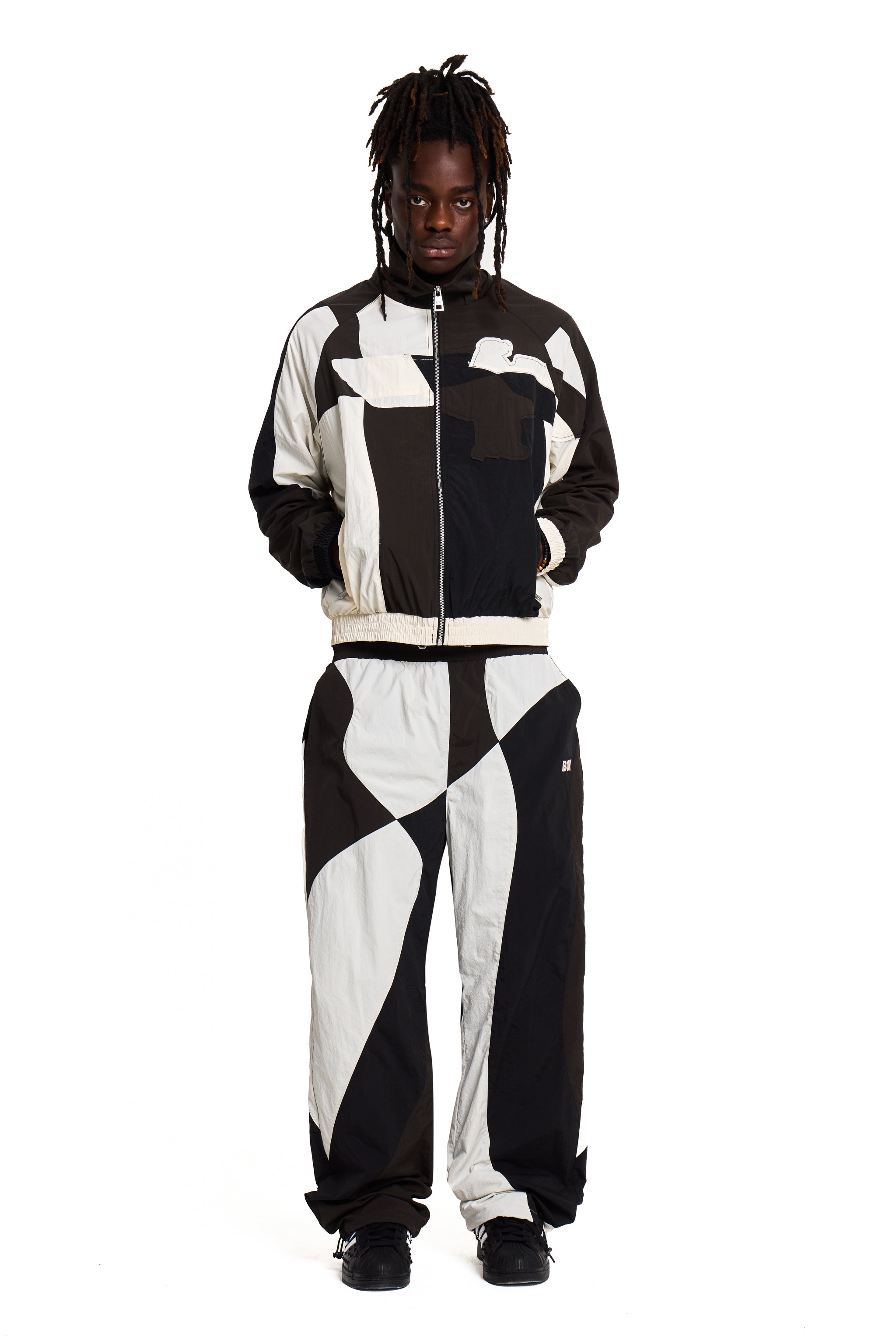 Person wearing a black and white Boy London checkered jumpsuit on a white background