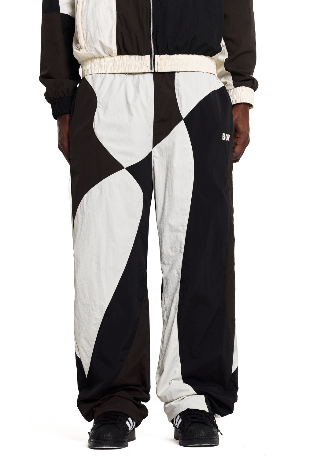 Black and white Boy London checkered pants worn by a person on a white background