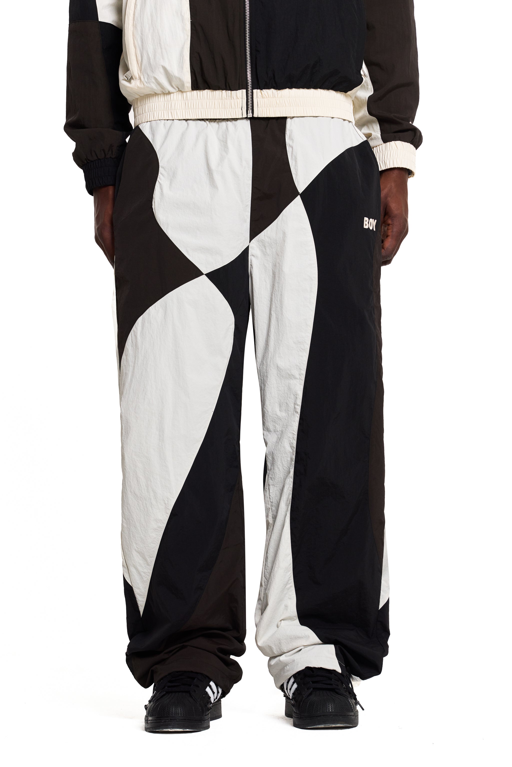 Black and white Boy London checkered pants worn by a person on a white background