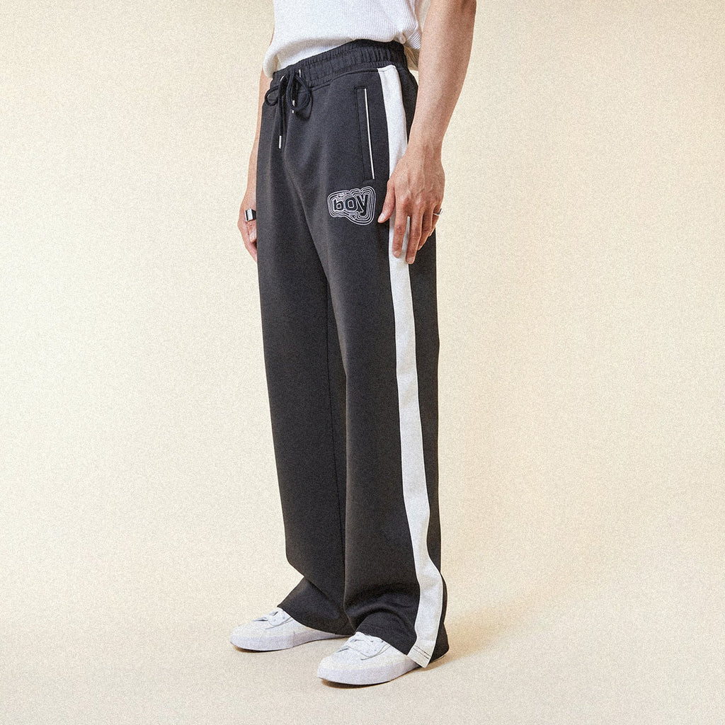 Black pants with a BOY London logo patch on a white background