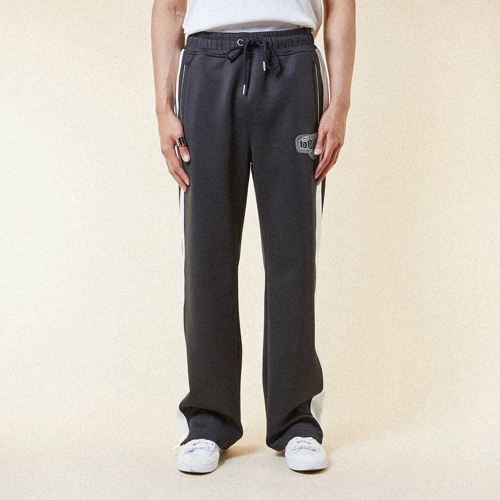 Black pants with a BOY London logo patch on a white background