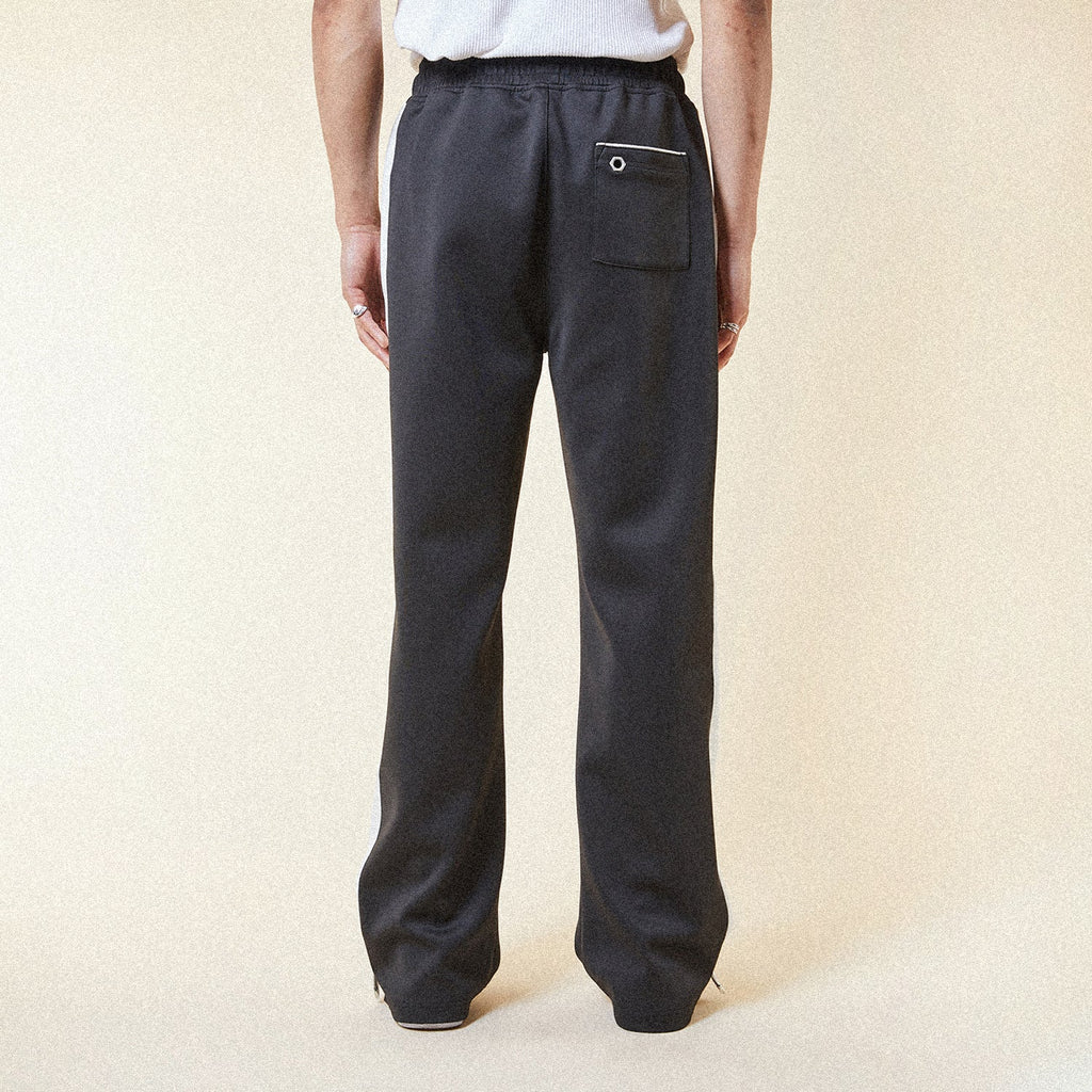 Black pants with a BOY London logo patch on a white background