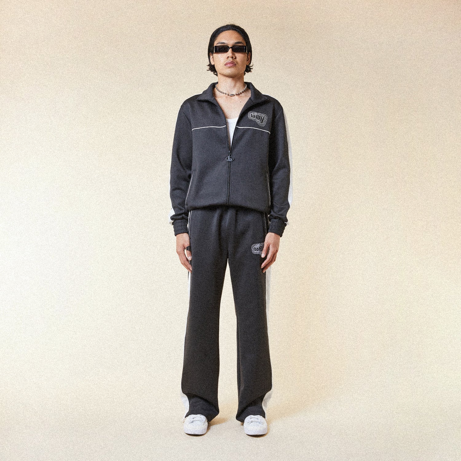 Black pants with a BOY London logo patch on a white background
