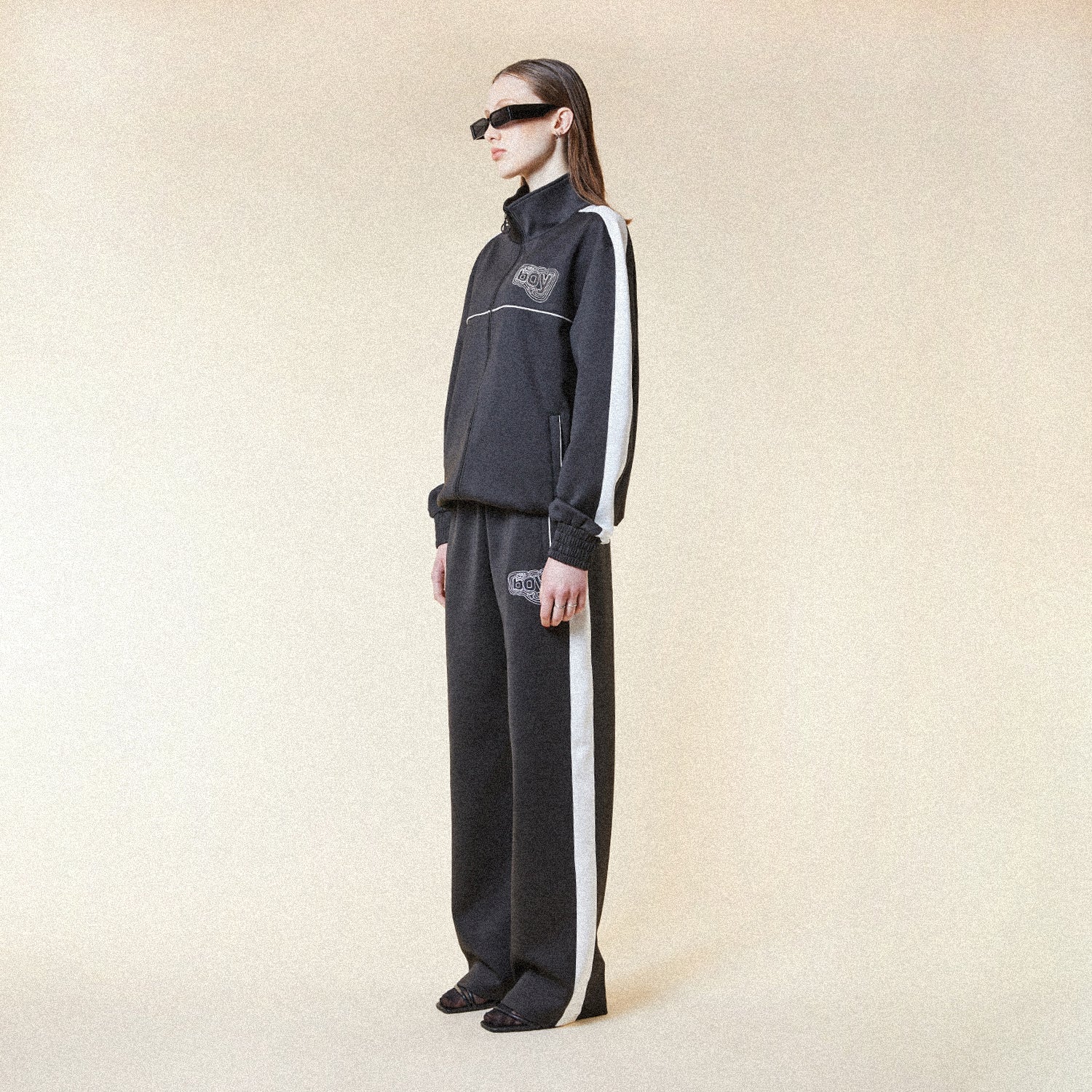 Black pants with a BOY London logo patch on a white background